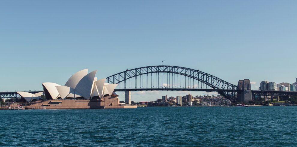 a bridge over water with a building and a city in the background